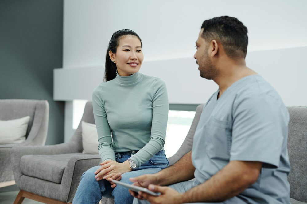 A Physical Therapist Talking to a Patient while Holding a clipboard
