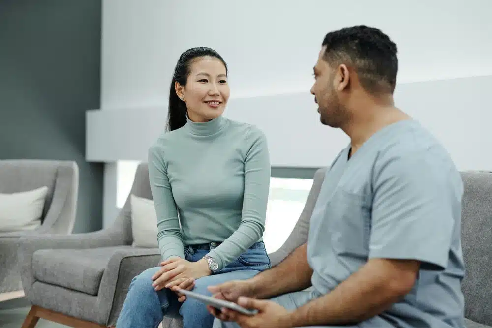 A Physical Therapist Talking to a Patient while Holding a clipboard